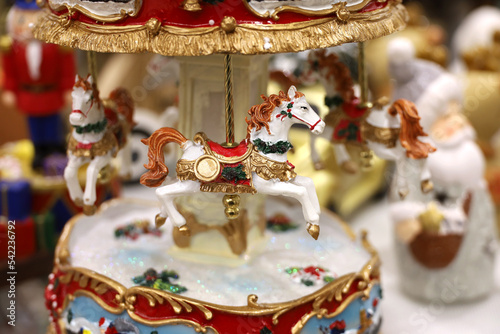 Porcelain figurines of horses, vintage carousel in gift shop on Christmas fair