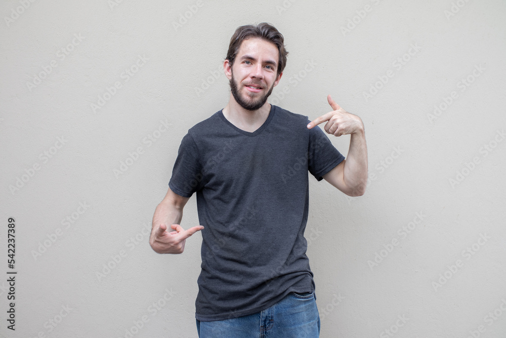 young Man in dark gray t-shirt mock-up isolated, fake printing shirt, front view pointing his chest young Man in dark gray t-shirt mock-up isolated, fake printing shirt, front view pointing his chest