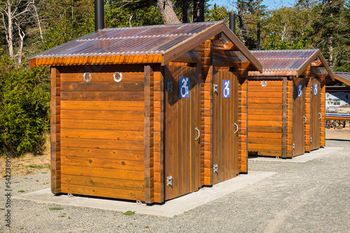 Public toilet in park. Sunny summer day Wooden restroom or toilet building in remote forest in park. Bathrooms or WC photo