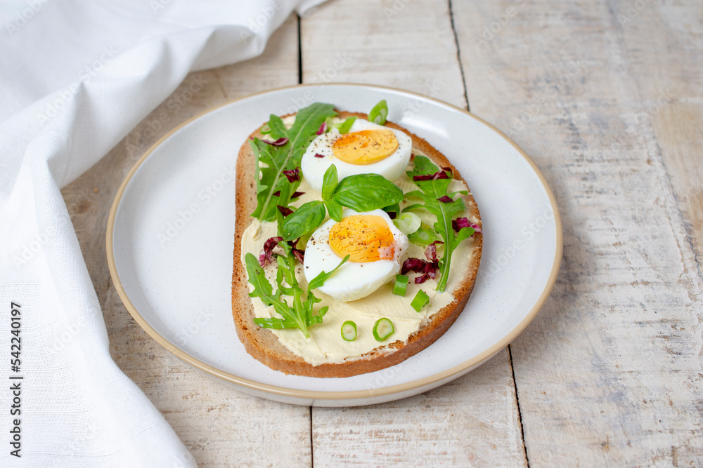 Boiled egg on bread with arugula. Healthy food Boiled egg on bread with arugula. Healthy food