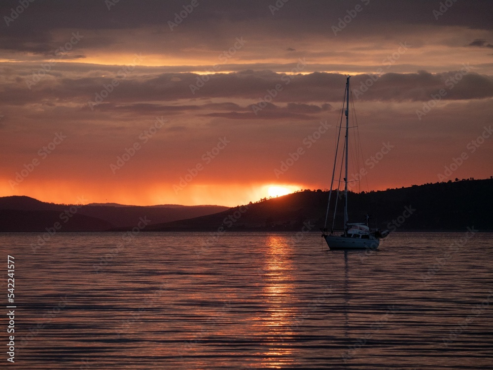 Breathtaking sunset view with seascape and a silhouette of boat