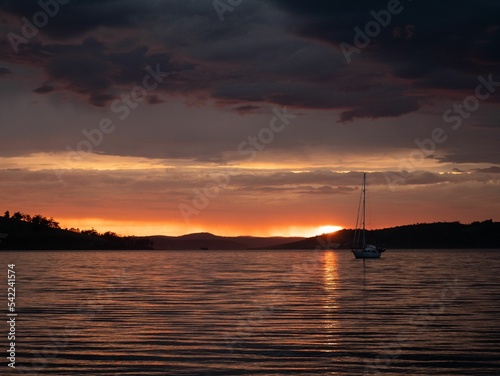 Breathtaking sunset view with seascape and a silhouette of boat © Toby Marshman/Wirestock Creators