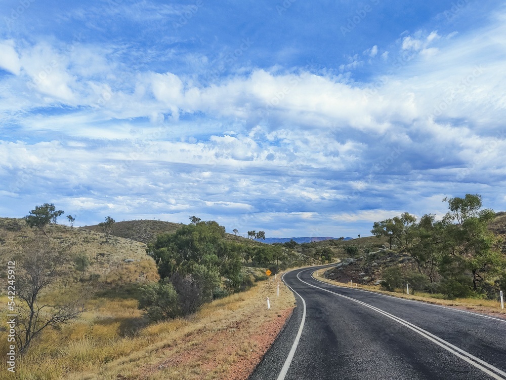 Beautiful shot of a road near the Ayers Rock during the day in Australia