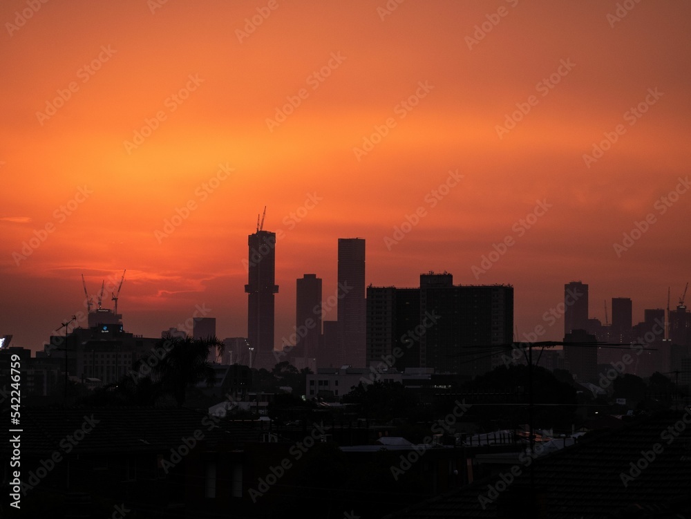 Silhouette of skyline against an orange sunset sky