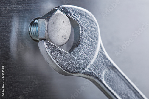 Fotografie Wrench tightens bolt in steel billet
