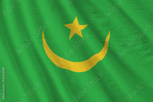 Mauritania flag with big folds waving close up under the studio light indoors. The official symbols and colors in banner photo