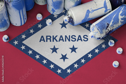 Arkansas US state flag and few used aerosol spray cans for graffiti painting. Street art culture concept photo