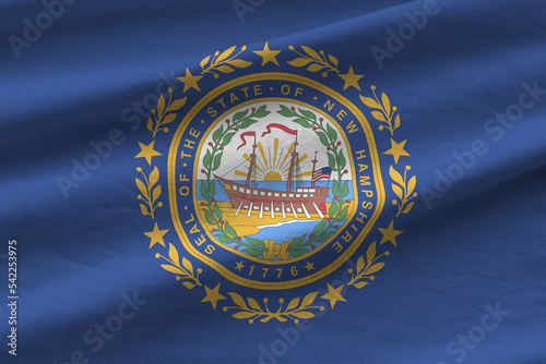 New Hampshire US state flag with big folds waving close up under the studio light indoors. The official symbols and colors in banner photo
