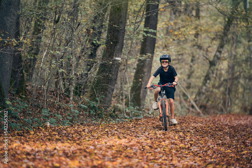 Enfant en vélo dans les bois en automne