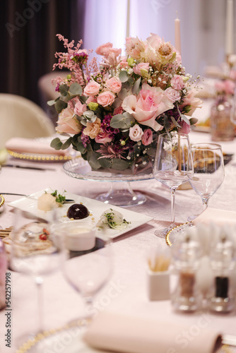 Beautiful pink flowers in bouquets on the batle in restaurant. Elegant decoration for the celebration © Aleksandr