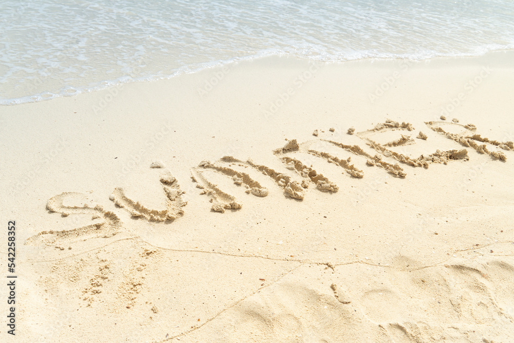 Fototapeta premium Close-up Of Summer Text Written On Sandy Beach Near The Seashore. Beach and sea.