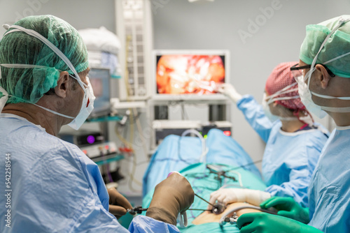 The surgeon's holing the instrument in abdomen of patient. The surgeon's doing laparoscopic surgery in the operating room. Minimally invasive surgery. uterus removal with surgical laparoscopy photo