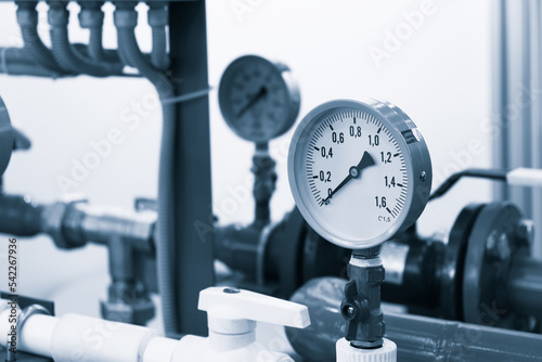 Industrial concept. equipment of the boiler-house, - valves, tubes, pressure gauges, thermometer. Close up of manometer, pipe, flow meter, water pumps and valves of heating system in a boiler room.