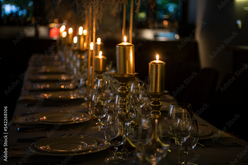 Luxury elegant table setting dinner with candles and light bulbs in a restaurant Luxury elegant table setting dinner with candles and light bulbs in a restaurant