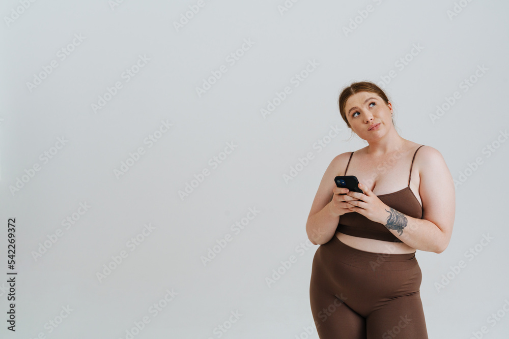© Drobot Dean - European puzzled woman with ginger hair using mobile phone © Drobot Dean - European puzzled woman with ginger hair using mobile phone