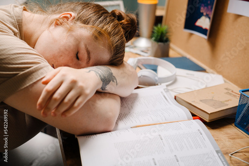 Fotografi Cropped portrait of young girl sleeping on books