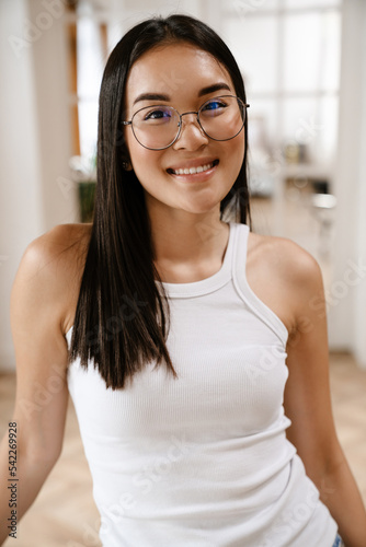 Young beautiful smiling asian woman in glasses looking at camera Free Download Young beautiful smiling asian woman in glasses looking at camera - GFXLoad