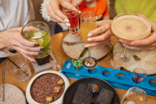 Clinking glasses with alcohol and toasting, party. photo