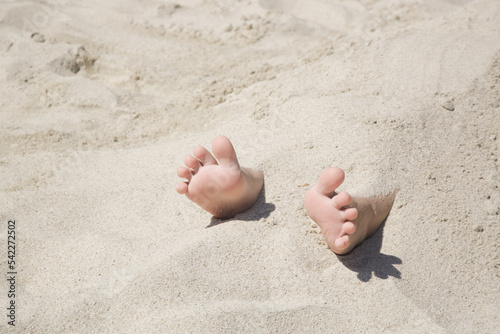 Billede på lærred Child feet buried in the sand on the beach