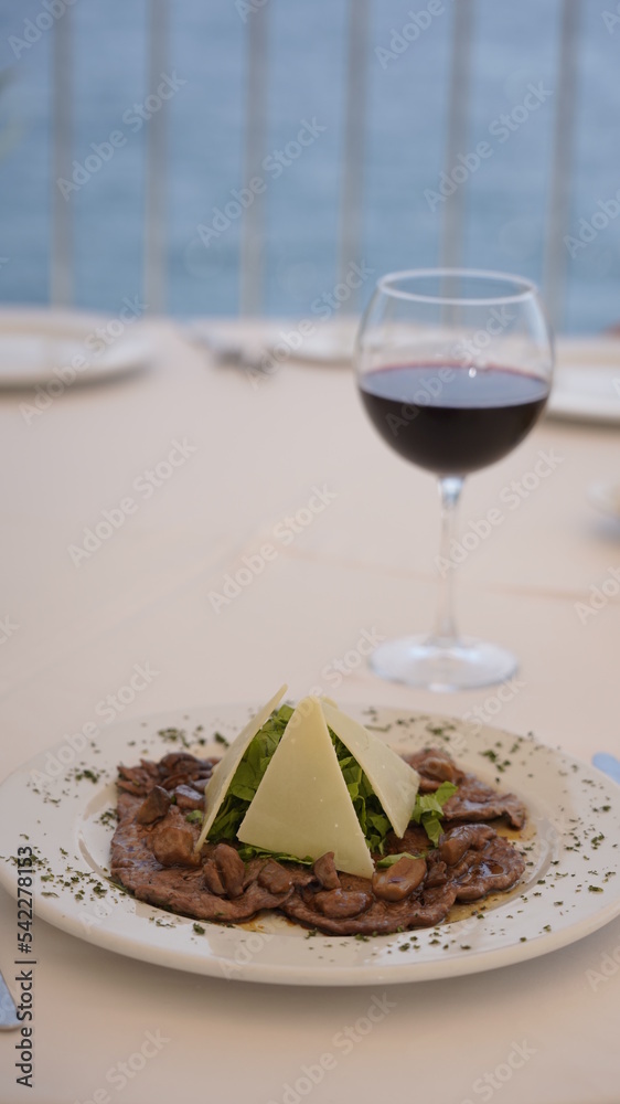 grilled meat presentation on a white plate and wine