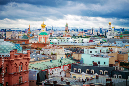 Churches and a tower with chimes against a blue sky with clouds in Moscow.