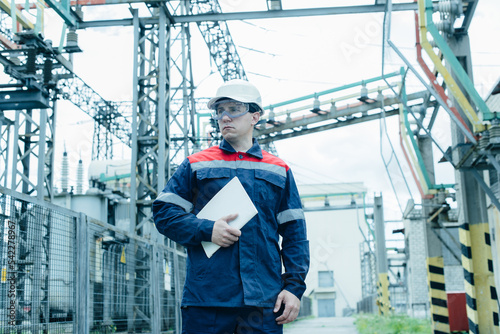 An energy engineer inspects the modern equipment of an electrical substation before commissioning. Energy and industry. Scheduled repair of electrical equipment.