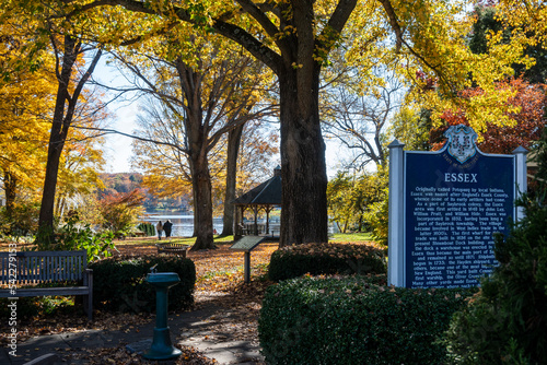 A public park in the New England town of Essex, Connecticut. A sign detailing the history of Essex is shown in the foreground. 