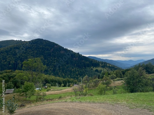 Landscape with dirt road in the mountains under cloudy sky