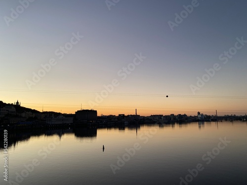 Beautiful sunset at Dnipro River with silhouette of cityscape