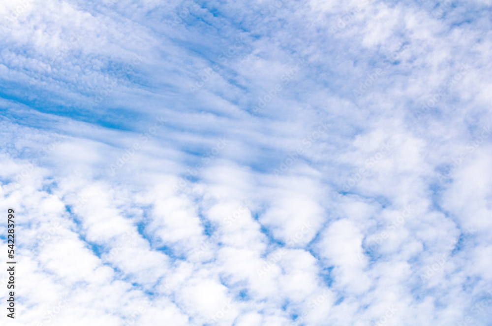 White cumulus clouds against blue sky. Atmospheric phenomena.	
