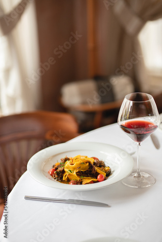 Appetizing Italian pasta with duck meat on a light background. Beautiful serving. Exquisite presentation of food.