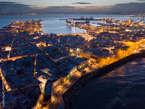 Panoramic view of illuminated Cadiz port city with medieval Cathedral at night, Spain