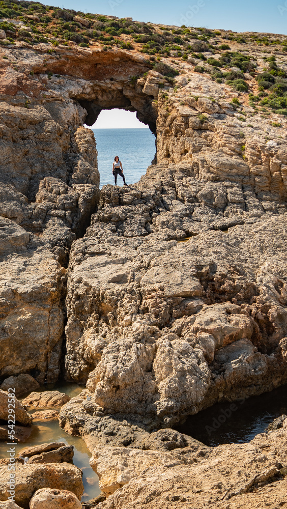 woman standing on a big cliff, admire the view, comino island, malta