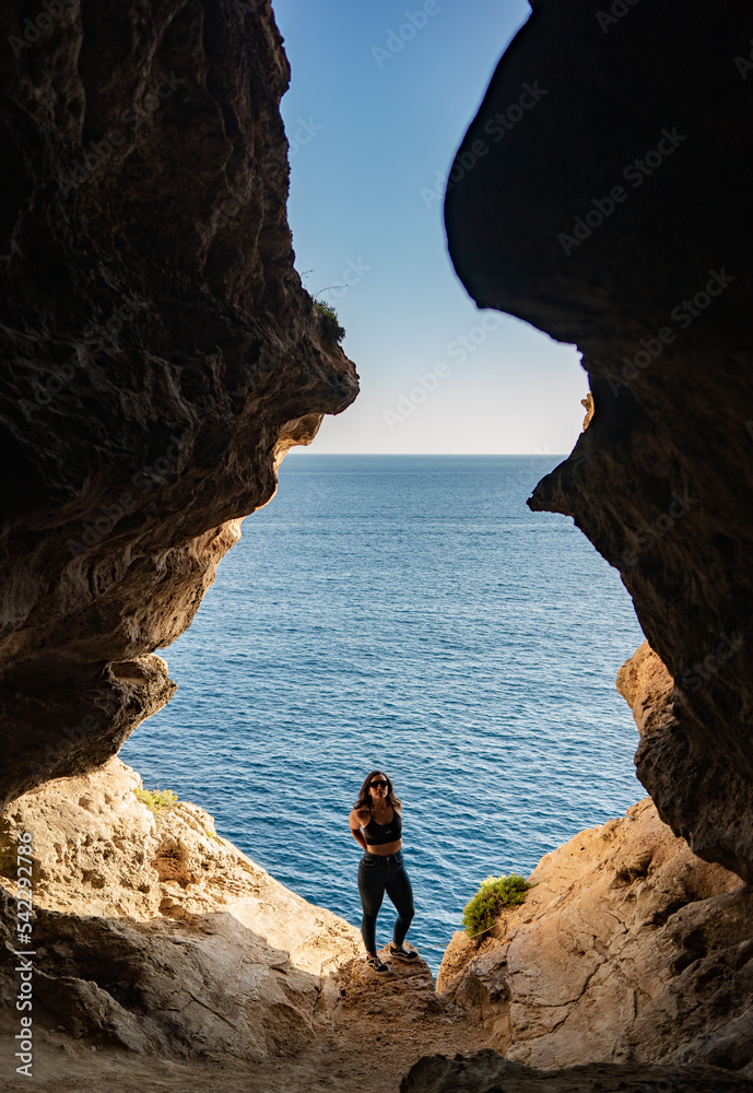 Girl is exploring caves, Għar ir-Riħ and Għar in-Nagħaġ, malta