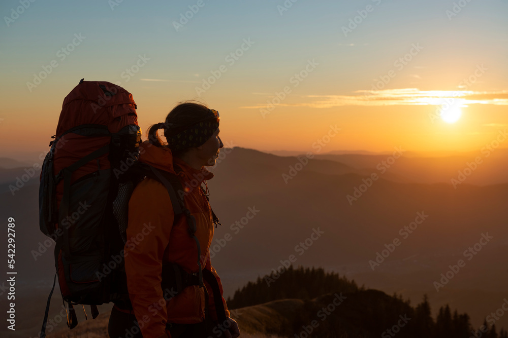 Female tourist watching the sunset in the mountains