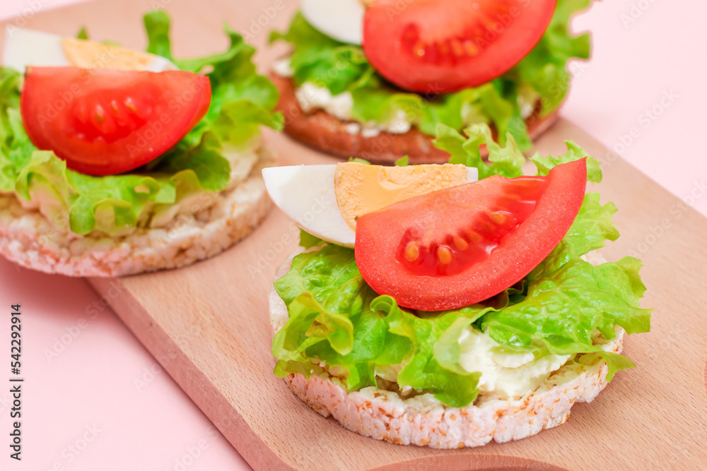 Rice Cake Sandwiches with Tomato, Lettuce and Egg on Wooden Cutting Board. Easy Breakfast. Diet Food. Quick and Healthy Sandwiches. Crispbread with Tasty Filling. Healthy Dietary Snack Rice Cake Sandwiches with Tomato, Lettuce and Egg on Wooden Cutting Board. Easy Breakfast. Diet Food. Quick and Healthy Sandwiches. Crispbread with Tasty Filling. Healthy Dietary Snack
