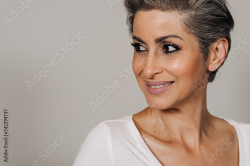 Beautiful senior woman with makeup looking aside and smiling