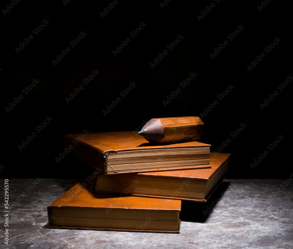 several books with the same binding on a dark background isolated. three books with a brown cover without inscriptions and titles with free space for text several books with the same binding on a dark background isolated. three books with a brown cover without inscriptions and titles with free space for text