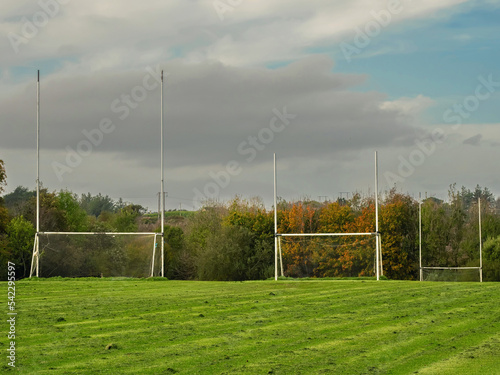 Training pitch for Irish National sport camogie, hurling, rugby and Gaelic football with tall goal posts and freshly cut grass. Nobody. Cloudy sky. Popular activity. © mark_gusev