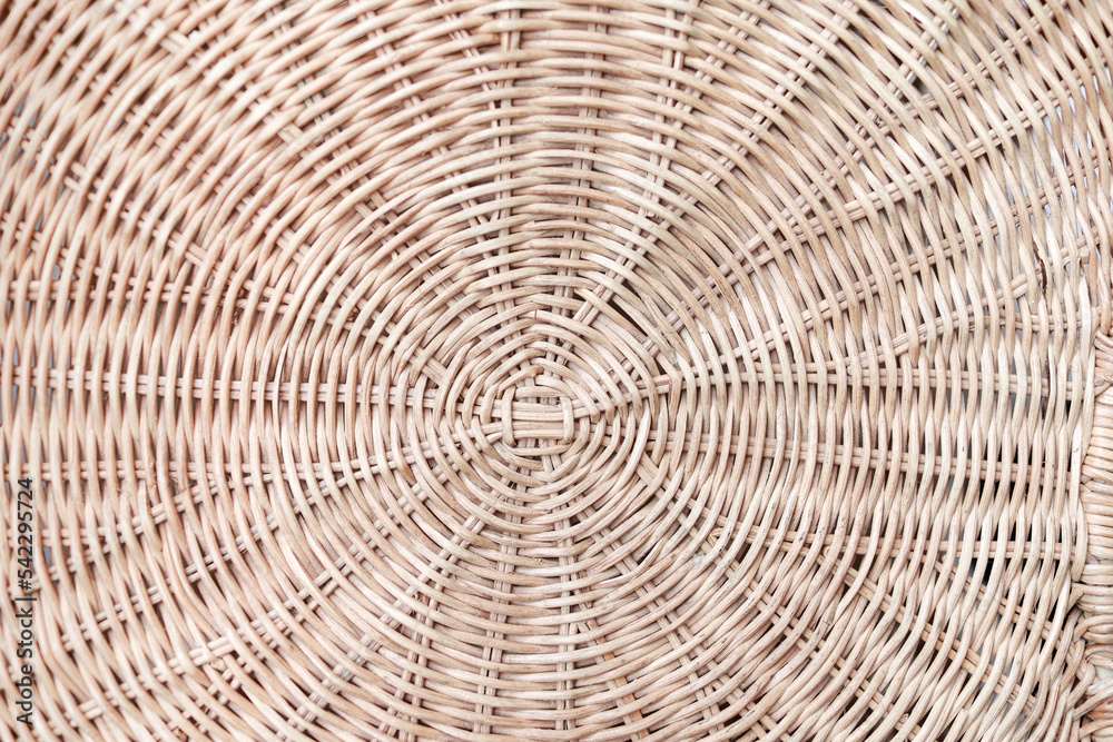 Circular weave rattan pattern, round rattan furniture background light brown texture, weave rattan texture and background. a fragment of a basket made of willow twigs or garden furniture, texture.