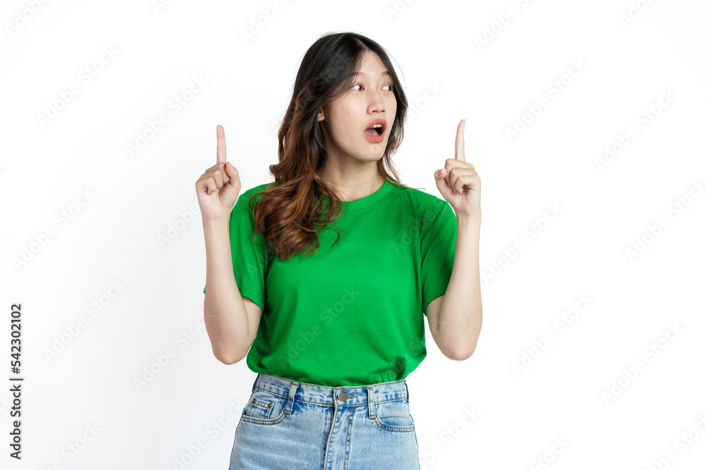 Beautiful confident Asian woman in green empty t-shirt isolated on white background. Point your finger to copy space to introduce products or services Beautiful confident Asian woman in green empty t-shirt isolated on white background. Point your finger to copy space to introduce products or services
