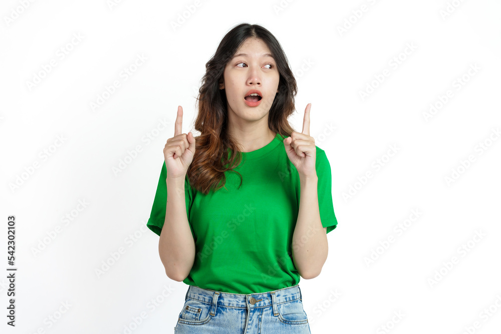 Beautiful confident Asian woman in green empty t-shirt isolated on white background. Point your finger to copy space to introduce products or services Beautiful confident Asian woman in green empty t-shirt isolated on white background. Point your finger to copy space to introduce products or services