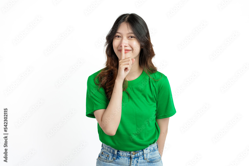 Beautiful confident Asian woman in green empty t-shirt isolated on white background. Use your index finger to cover your mouth with a lie or not loudly concept Beautiful confident Asian woman in green empty t-shirt isolated on white background. Use your index finger to cover your mouth with a lie or not loudly concept