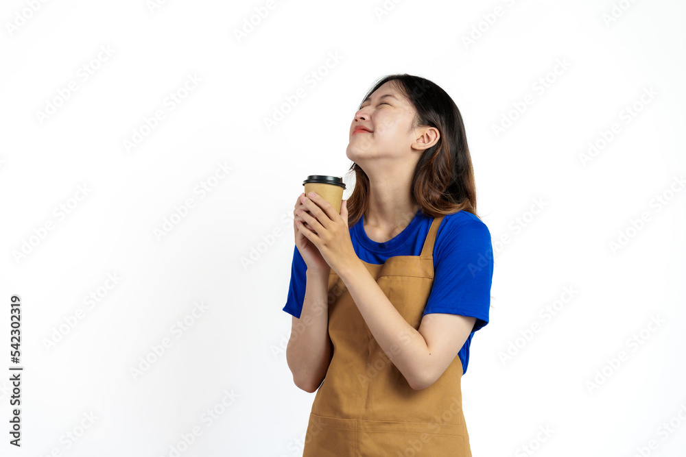 Cheerful young pretty asian woman blue t-shirt and apron coffee owner isolated on white background. Holding paper coffee cup Cheerful young pretty asian woman blue t-shirt and apron coffee owner isolated on white background. Holding paper coffee cup
