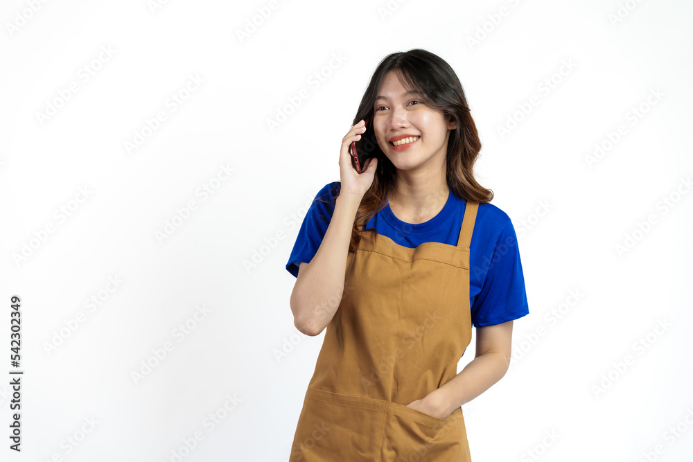 Cheerful young pretty asian woman blue t-shirt and apron coffee owner isolated on white background. call mobile phone, recieve order Cheerful young pretty asian woman blue t-shirt and apron coffee owner isolated on white background. call mobile phone, recieve order