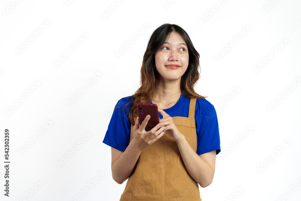 Cheerful young pretty asian woman blue t-shirt and apron coffee owner isolated on white background. Receive orders from the mobile app Cheerful young pretty asian woman blue t-shirt and apron coffee owner isolated on white background. Receive orders from the mobile app