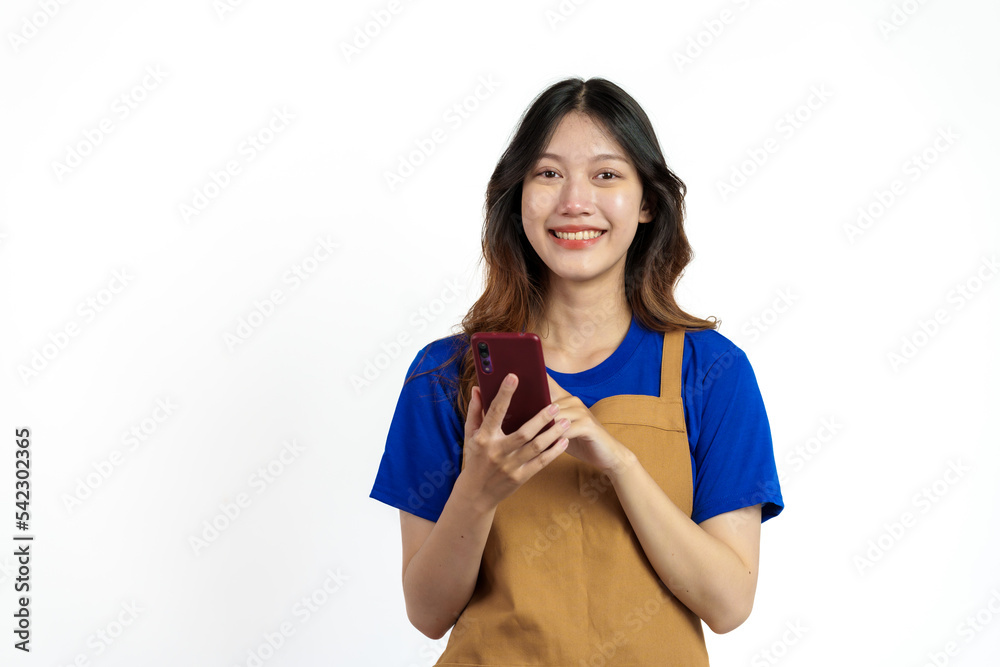 Cheerful young pretty asian woman blue t-shirt and apron coffee owner isolated on white background. Receive orders from the mobile app Cheerful young pretty asian woman blue t-shirt and apron coffee owner isolated on white background. Receive orders from the mobile app