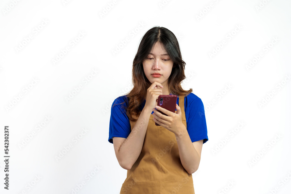 Cheerful young pretty asian woman blue t-shirt and apron coffee owner isolated on white background. Receive orders from the mobile app Cheerful young pretty asian woman blue t-shirt and apron coffee owner isolated on white background. Receive orders from the mobile app