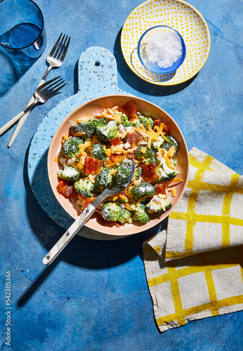 Broccoli salad with cheese and bacon on blue table