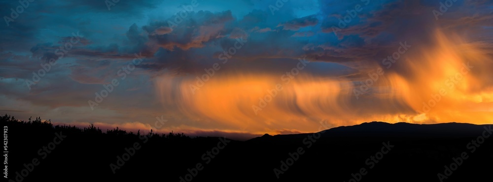 Panoramic shot of a beautiful sunset with a cloudy sky over a landscape Panoramic shot of a beautiful sunset with a cloudy sky over a landscape